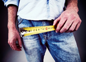The man measures his penis with a tape measure